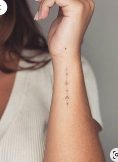 a woman's arm with a small star tattoo on the left side of her wrist