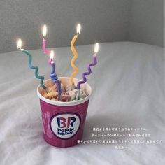 a cup filled with lots of candy and lit candles