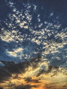 the sun is setting behind some clouds in the sky