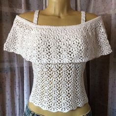 a mannequin wearing a white crochet top