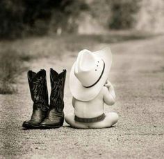 a cowboy hat sitting on the ground next to two boots