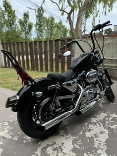 a black motorcycle parked in front of a wooden fence