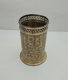 an ornately decorated metal cup sitting on a table