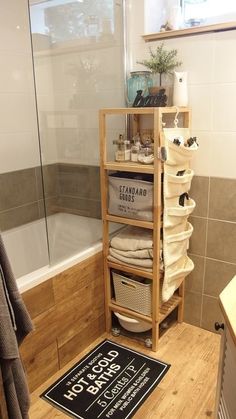 a wooden shelf filled with lots of items in a bathroom next to a bath tub