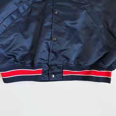 "Here is a 1990s Asheville Tourists game issued jacket by Wilson. The navy blue button-up features \"Tourists\" on the front in red on white. The sleeve cuffs, collar and waist are elastic with navy-white-red colors. There are two front pockets. A Wilson manufacturer's size 42 label is stitched on the inside collar. Features - Color: red, white and navy blue - Two front pockets - Made in the USA Condition - Brand: Wilson - Year Made: 1990s - Size: 42 Medium - This jacket is in mint condition. - Classic Collared Windbreaker For Streetwear, Retro College Outerwear With Button Closure, Retro Outerwear With Button Closure For College, Retro Streetwear Outerwear With Button Closure, Retro Outerwear With Button Closure For Streetwear, College Varsity Jacket With Button Closure, Navy Varsity Jacket With Pockets For Streetwear, Navy Casual Outerwear For Sports Events, Casual Navy Outerwear For Sports Events