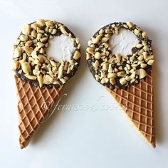 two ice cream cones with sprinkles and nuts in them on top of each other