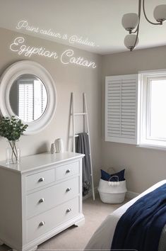 a white dresser sitting in a bedroom next to a window with shutters on it