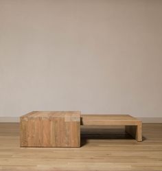 a wooden table sitting on top of a hard wood floor next to a white wall