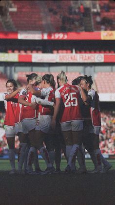 a group of women's soccer players huddle together at the end of a game