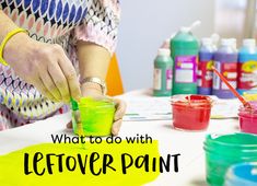 a woman is painting with green paint on the table next to other paints and containers