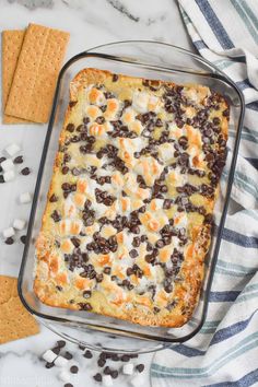 a casserole dish with chocolate chips and marshmallows on the side