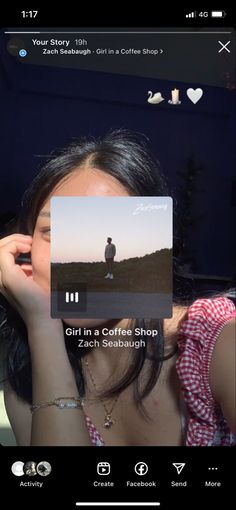 a girl in a coffee shop looking at her cell phone with the caption'girl in a coffee shop '