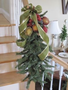 a bunch of fruit is tied to a christmas tree on the bannisters handrail