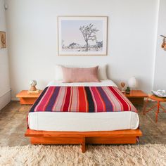 a bed sitting in a bedroom on top of a wooden platform next to a table