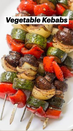 grilled vegetables on skewers sitting on a white plate