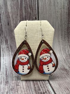 Snowman dangle earrings with a bright red scarf and Santa hat. Made with wood and stainless steel. Red Earrings For Winter Gift, Wood Burned Earrings, Wood Dangle Earrings, Red Scarf, Red Scarves, Etsy Earrings Dangle, Diy Earrings, Santa Hat, Bright Red