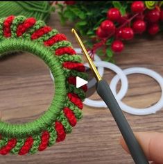 someone is crocheting a christmas wreath with yarn and scissors to make it look like an ornament