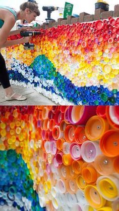 there is a woman standing next to a wall made out of plastic cups