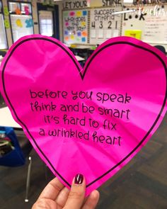 someone holding up a pink paper heart with the words before you speak think and be smart it's hard to fix a wrinkled heart