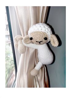 a stuffed sheep hanging from the side of a curtain