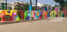 a colorful wall painted with many different colors and designs in the middle of a city