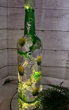 a glass bottle with flowers painted on it