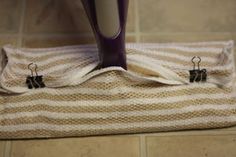 a hair dryer sitting on top of a towel next to a vase with purple handles