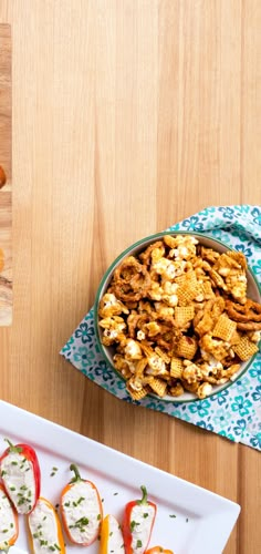 some food is on a white plate and next to a bowl of crackers with cheese