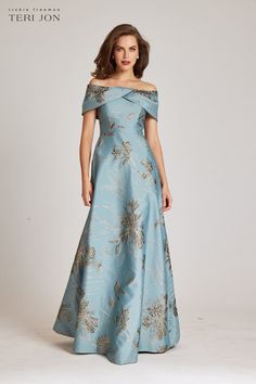 A jaw dropping evening gown! This Jacquard metallic gown has an off the shoulder twisted neckline. The cap sleeves add an elegant touch while also offering the ideal amount of sleeve coverage that is always sought out. Also incorporated is a visible high waistline and full a-line skirt to elevate the look. This is a mo Sleeved Mother Of The Bride Dresses, Dusty Blue Mother Of The Bride Dress Long, Elegant Mother Of The Bride Dresses Blue, Classy Dress Outfits For Wedding, Sister Of The Bride Dress, Mother Of The Bride Dresses Vintage, Petite Gowns, Metallic Gown, Off Shoulder Evening Gown