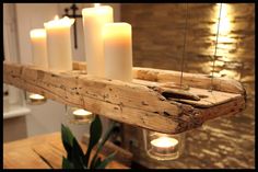 some candles are lit on a wooden shelf