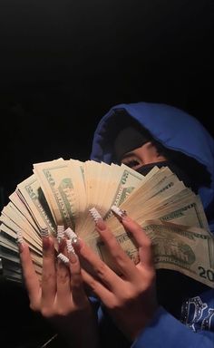 a person in a blue hoodie holding money