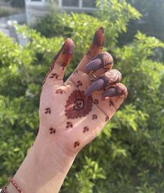 a woman's hand with hendix on it and nails in the shape of flowers