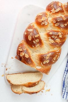 a loaf of bread sitting on top of a white cutting board next to a blue and white towel