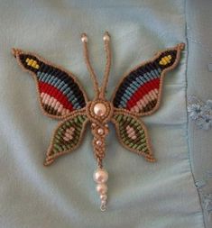 a beaded butterfly with pearls on it's wings