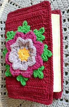 a crocheted book with a flower on it