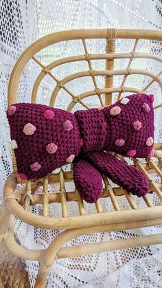 three purple knitted teddy bears sitting on a wicker chair