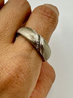 A refined vintage wedding band. If you are on the hunt for the ring that will grace your hand forever, look no further! This timeless piece is in sterling silver with a row of diamonds. Balancing masculine and romantic. Marked: P4SR Jewelry Measurements: Ring Size: 12.5 Condition: AB. See the Condition Grade Scale on the photo carousel. Damage to consider: See images Care: Clean with a sunshine cloth, use warm water and dish soap when necessary for a deeper clean. Disclaimer: Vintage items are u Classic Channel Set Ring For Promise, Classic Promise Ring With Channel Set, Classic Promise Rings With Channel Set, Classic Bands With Single Cut Diamonds For Promise Ring, Classic Promise Bands With Diamond Accents, Timeless Silver Channel Set Wedding Ring, Classic Promise Diamond Ring Channel Set, Classic Silver Diamond Band, Classic Sterling Silver Promise Bands