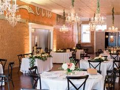 tables and chairs are set up for a formal function with chandeliers hanging from the ceiling