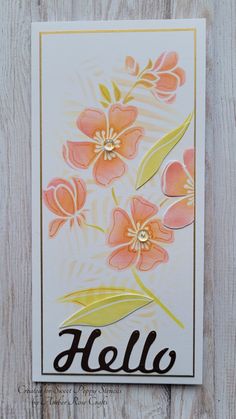 a card with flowers and the word hello written in black ink on white wood background