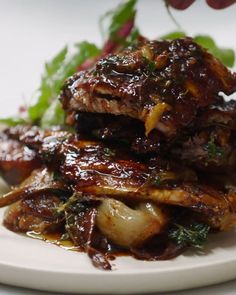 some meat and vegetables on a white plate with sauce in the middle, ready to be eaten