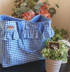 a blue and white checkered tote bag next to a potted plant