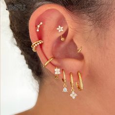 a woman wearing three different types of ear piercings on her left side of the ear