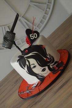 a cake decorated with a woman's face and number 50 on the top, sitting on a wooden table