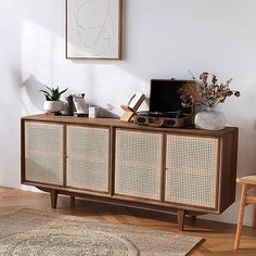 a living room with a rug, chair and sideboard