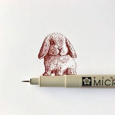 a pen with a drawing of a rabbit on it's side and the word micro written in red ink