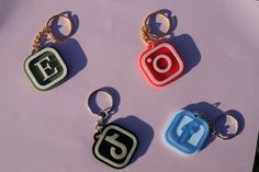 four key chains with different colored instagrams on them sitting next to each other