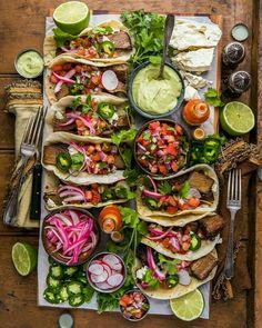 mexican food with tortillas, guacamole and salsa on a wooden table