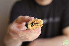 a man is holding a sandwich in his hand while he looks at the food on the plate