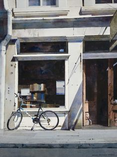 a bicycle parked in front of a building with books on the window sill and an open door