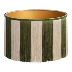 a green and white lamp shade with fringe trim